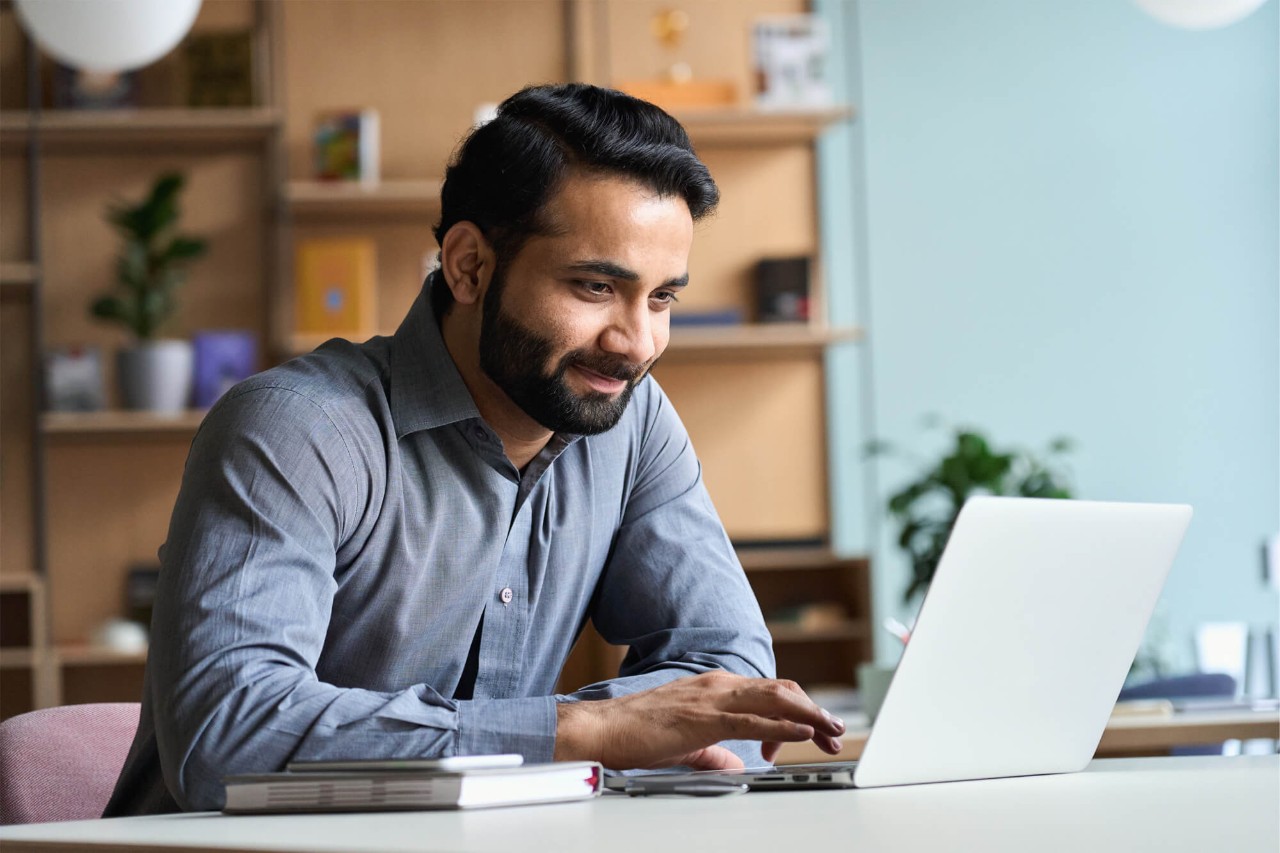 Applied administration graduate working on a laptop.