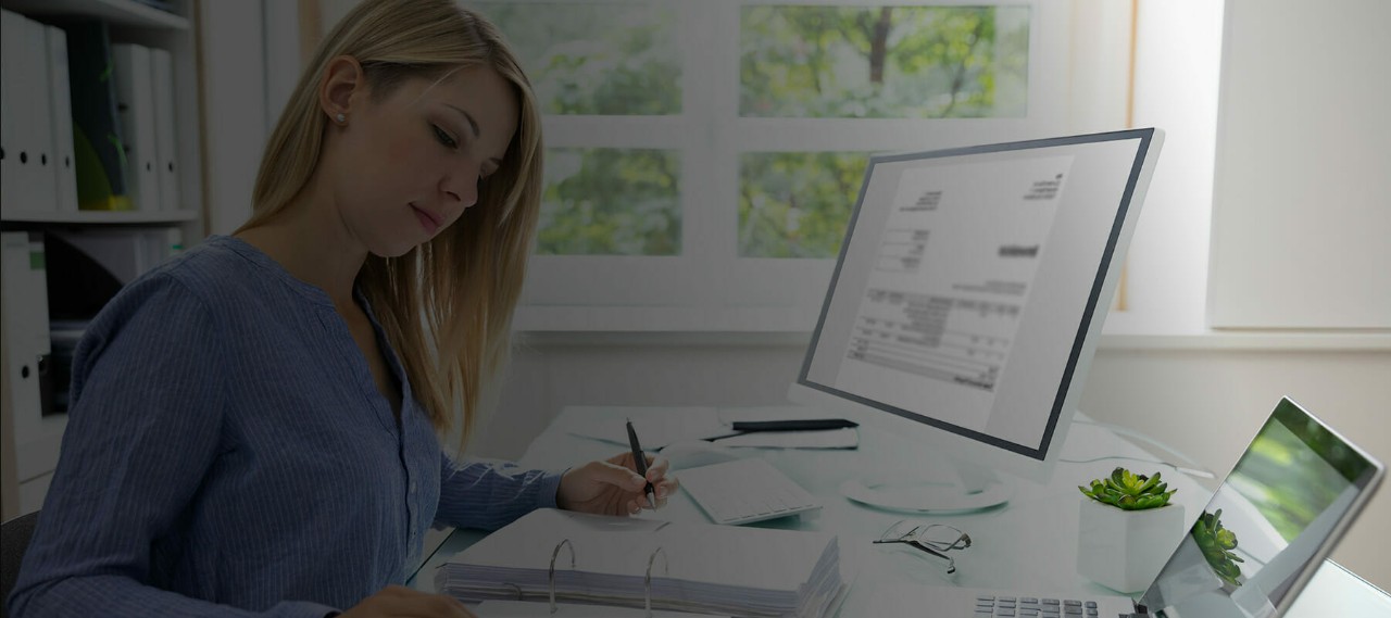 Young Businesswoman Calculating Bill With Computer And Laptop On Desk